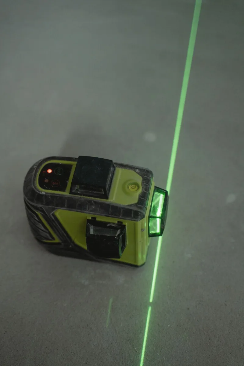 Groene laserlijn geprojecteerd op een betonvloer